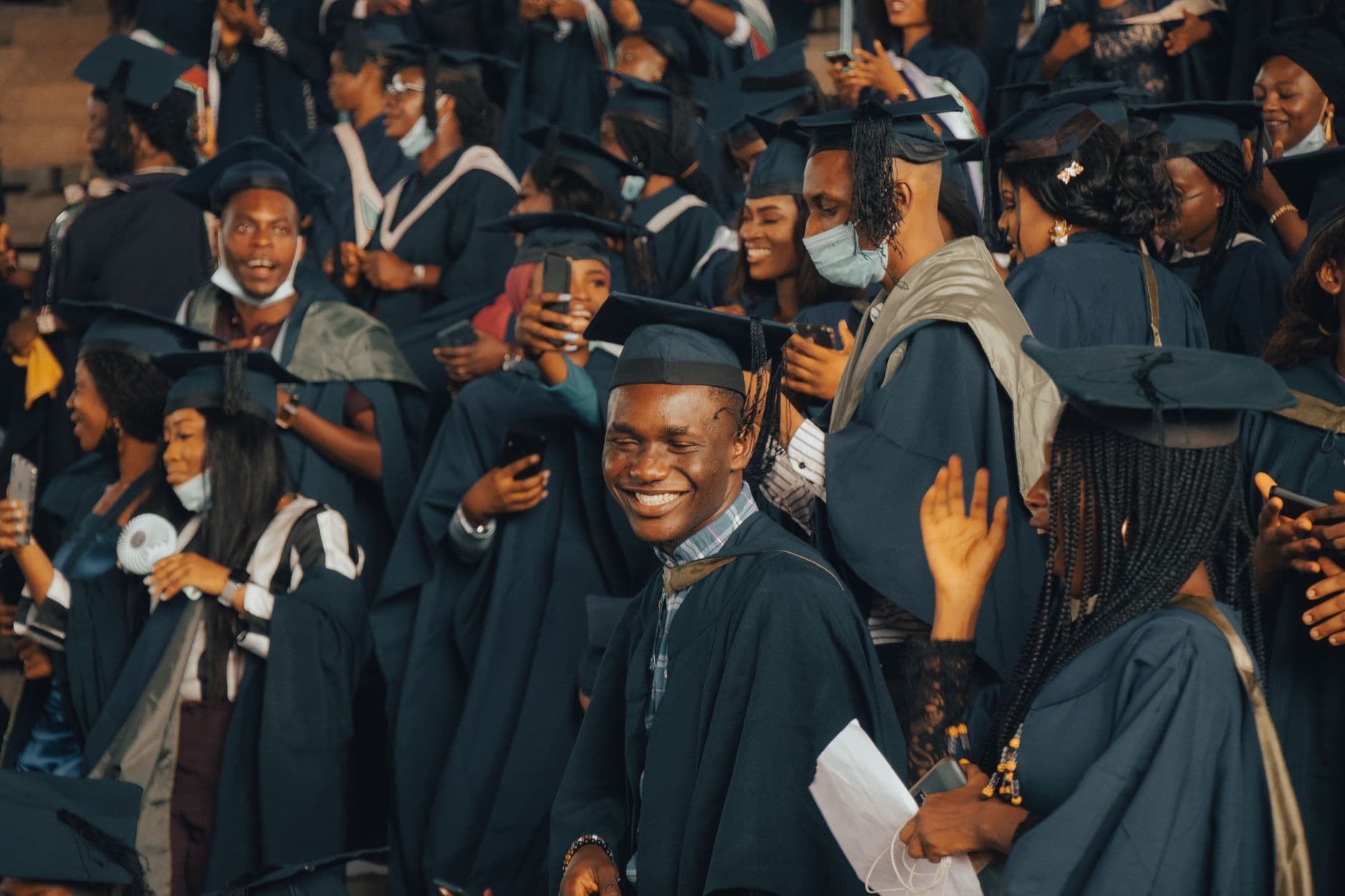 Graduates in gowns, smiling